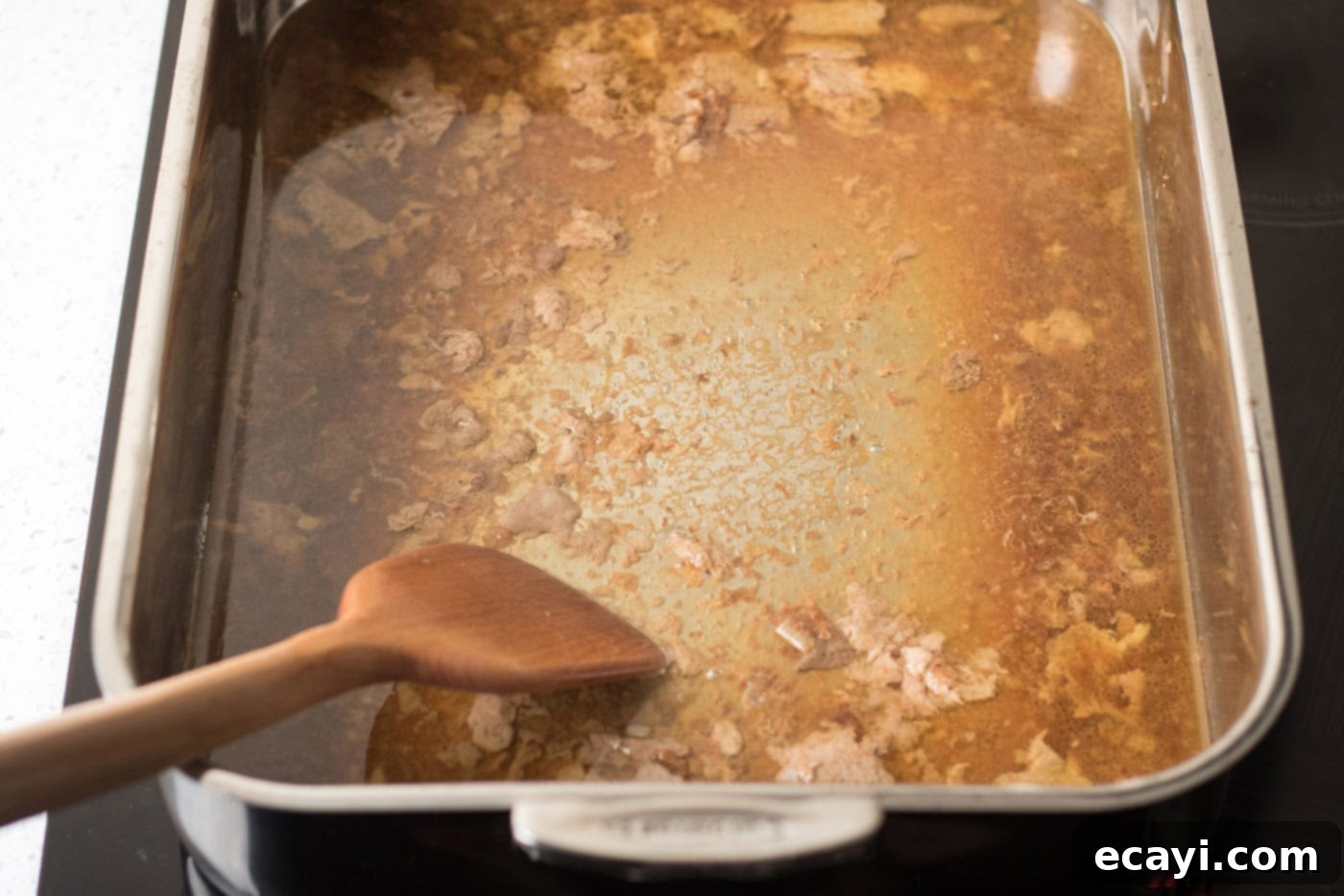 Perfect Turkey Gravy From Scratch 6 Spatula in a roasting pan full of pan drippings