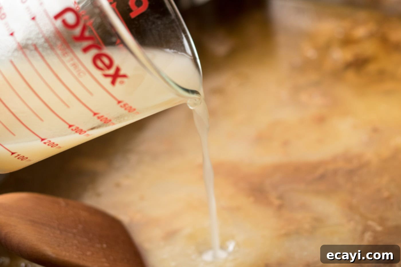 Perfect Turkey Gravy From Scratch 7 Broth being poured into a roasting pan