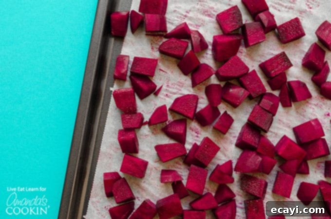 Roasted beets are the star of this easy, healthy Pearl Couscous Salad with Feta, adding natural sweetness and vibrant color. #couscous #feta #beets #dinnersides #sidedish #healthy #healthysides #salad #sidesalad #vegetarian Fresh red beets on a baking sheet, glistening with olive oil, ready for roasting to enhance their natural sweetness and tenderness.
