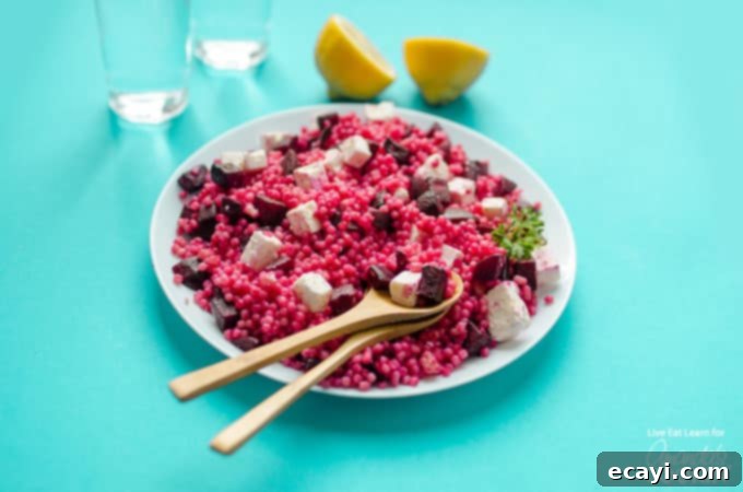 Serve up this incredible Pearl Couscous Salad with Feta and Beet for a nutritious and colorful side dish or light meal. #couscous #feta #beets #dinnersides #sidedish #healthy #healthysides #salad #sidesalad #vegetarian A single serving of Pearl Couscous Salad with Feta and Beets on a white plate, beautifully composed and ready to be enjoyed as a healthy meal.