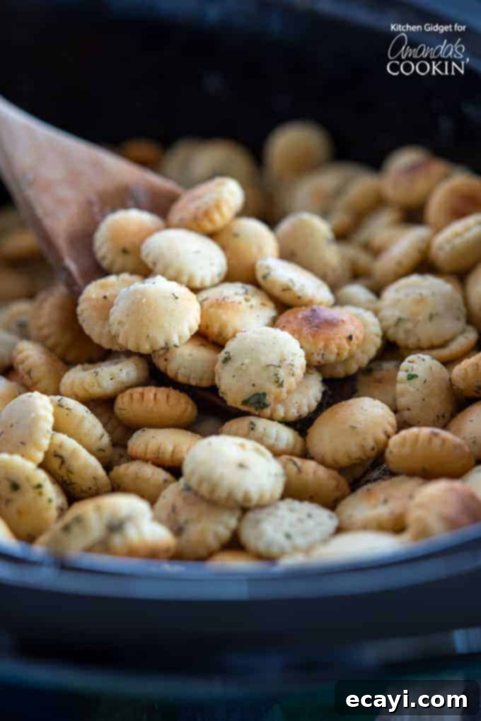 Slow cooker method for ranch seasoned oyster crackers: A convenient way to prepare this zesty dill and garlic snack, perfect for parties and game day appetizers. #appetizers #appetizerrecipes #oystercrackers #superbowl #gamedayappetizers #gameday #crockpot #garlic #slowcooker #ranch #partyfood #partyappetizers Freshly seasoned oyster crackers in a slow cooker, ready to be cooked