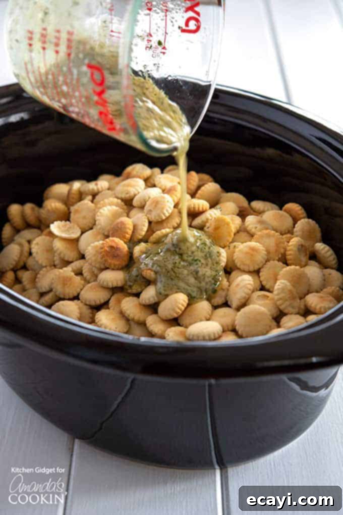 Mixing ranch seasoning with oyster crackers: The first step to creating crispy, savory homemade party snacks with dill and garlic flavor. #appetizers #appetizerrecipes #oystercrackers #superbowl #gamedayappetizers #gameday #crockpot #garlic #slowcooker #ranch #partyfood #partyappetizers Close-up of butter and ranch seasoning being poured over oyster crackers in a bowl