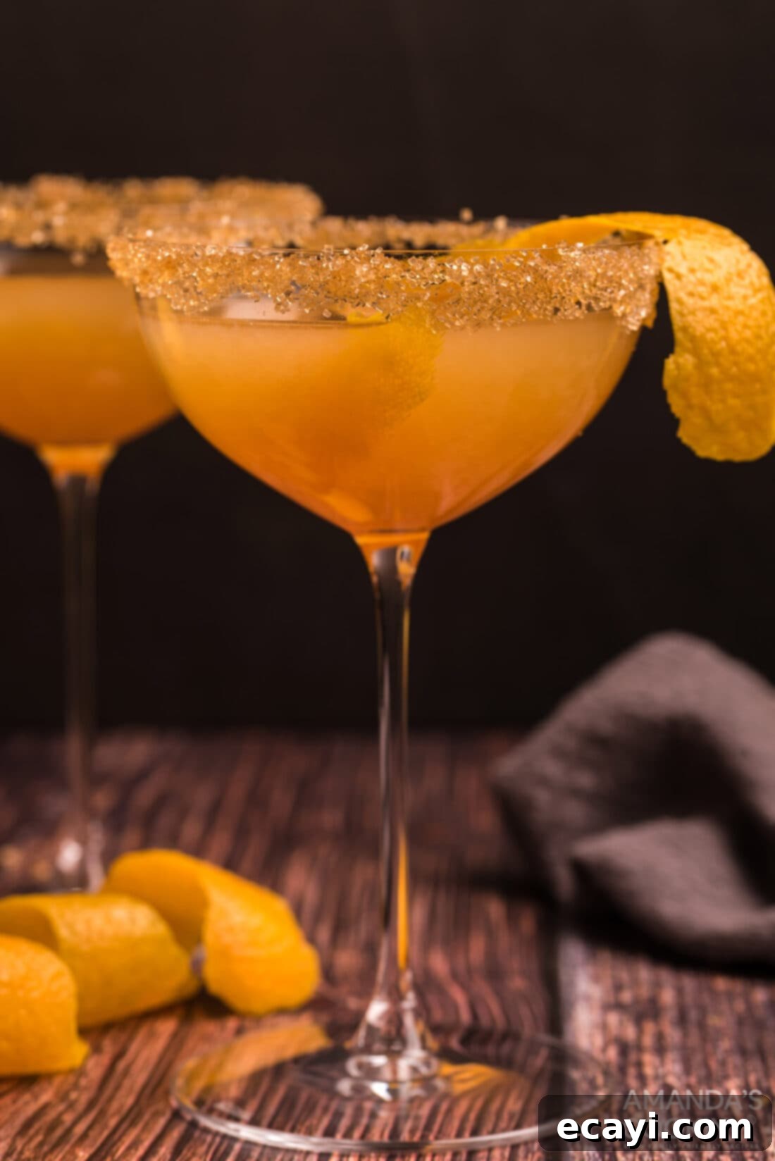 Sidecar: Tangy Elegance 2 Close up photo of a Sidecar Cocktail, showing its vibrant golden hue and an orange peel garnish in a coupe glass.