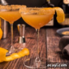 Sidecar: Tangy Elegance 9 A chilled coupe glass holding a golden Sidecar cocktail, garnished with a vibrant orange twist.