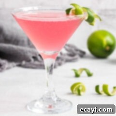 The Iconic Cosmopolitan Cocktail 8 A vibrant pink Cosmopolitan cocktail in a martini glass, garnished with a fresh lime twist.