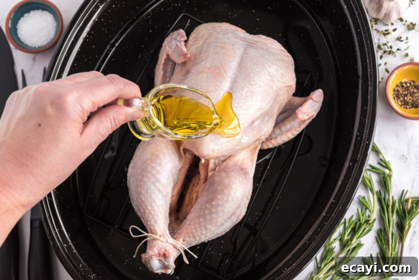 Golden Herb Roasted Chicken 6 Çiğ tavuğa kızartma tavasında zeytinyağı dökülüyor