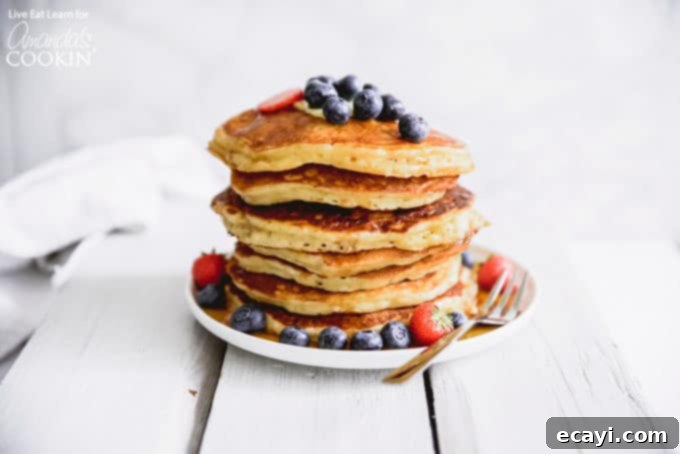 These classic buttermilk pancakes are fluffy, filling, and so delicious. Homemade pancakes are easier than you thought, so throw away that box mix! #breakfast #breakfastrecipes #buttermilkpancakes #pancakes #homemadepancakes A beautifully arranged stack of fluffy homemade buttermilk pancakes, ready to be served.