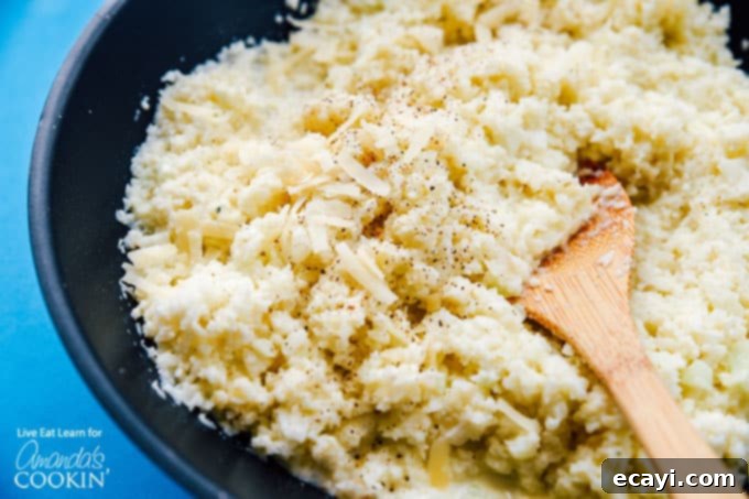 Creamy and Flavorful Cauliflower Risotto – A Healthy and Satisfying Meal Ready in Minutes. #risotto #lowcarb #asparagus #cauliflowerrice #cauliflowerrecipes #dinnerrecipes #garlic Close-up shot of creamy cauliflower risotto simmering in a large saute pan, showing its rich texture and readiness to be served.