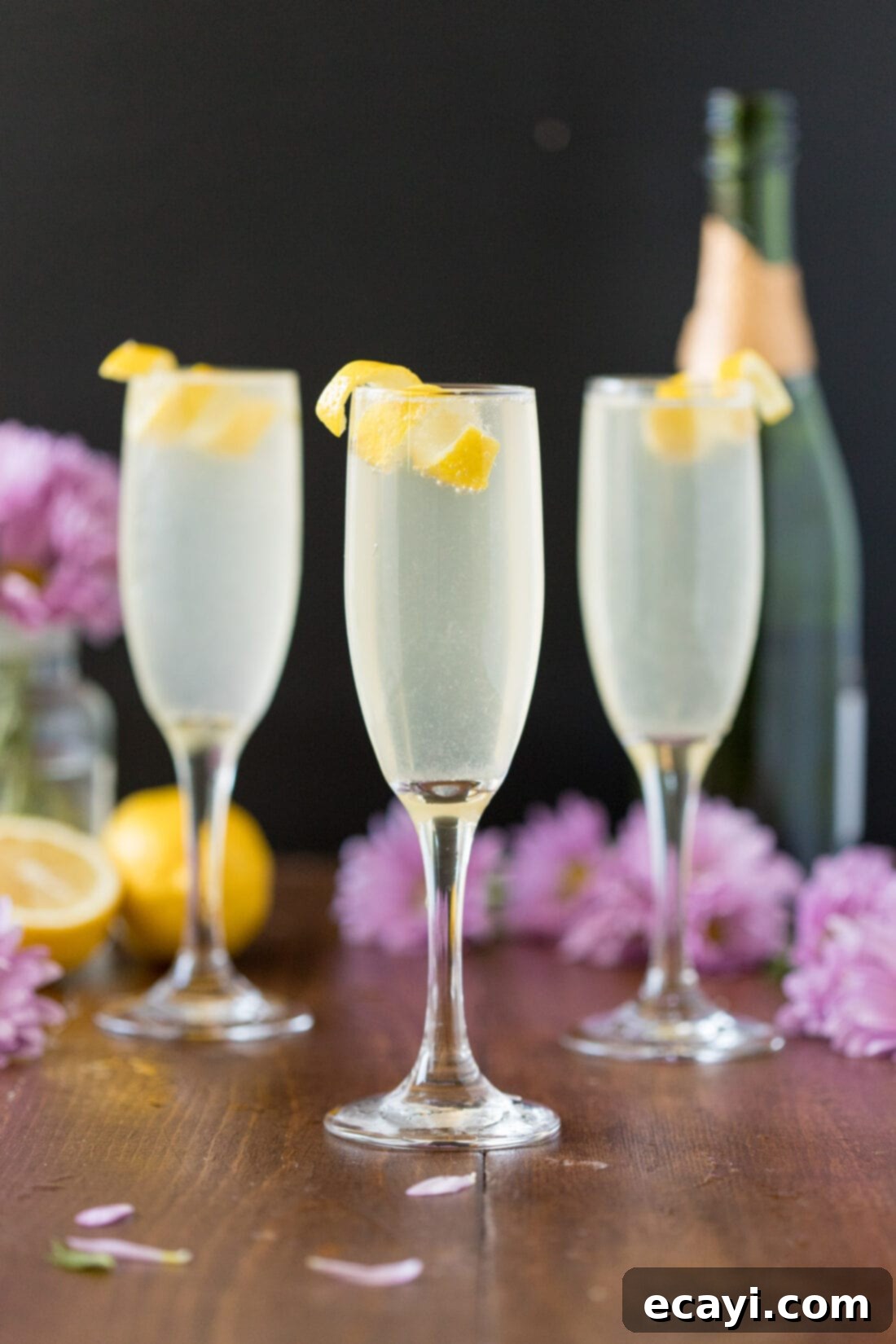 Serve up these gorgeous French 75 cocktails for your next brunch, wedding, or holiday party – they're perfect for any festive moment, especially Mother's Day, or as a delightful summer bubbly lemonade. A trio of French 75 cocktails in champagne flutes, garnished with lemon twists, ready to be served.