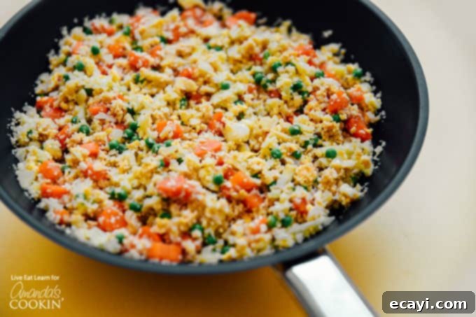 This Cauliflower Fried Rice is a delicious, low carb alternative to traditional fried rice. Keto friendly and super easy to make! #friedrice #keto #lowcarb #cauliflower #cauliflowerrecipes #cauliflowerrice #dinnersides #healthy #healthysides Cauliflower fried rice in wok