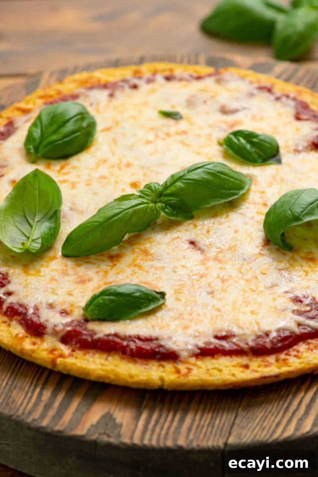 Cauliflower Power Crust 6 Cauliflower Pizza Crust pizza topped with fresh basil leaves and vibrant melted cheese, a healthy and delicious meal option.