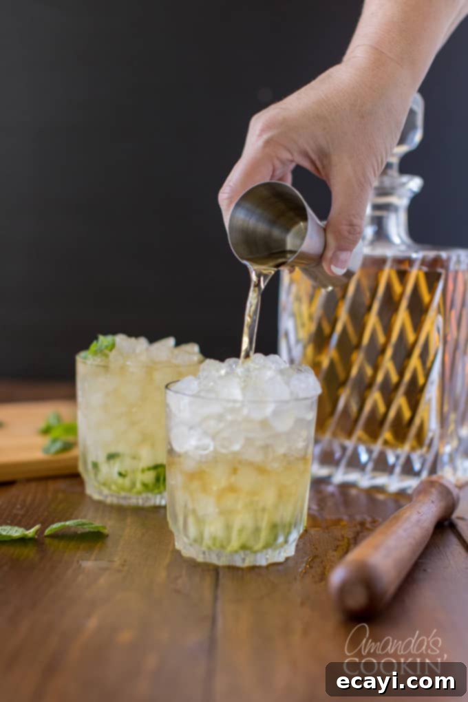 The classic Mint Julep, signature drink of the Kentucky Derby, is made with bourbon whiskey and served in a highball glass or a silver julep cup. This easy cocktail recipe showcases the importance of quality bourbon. Pouring bourbon whiskey into a highball glass filled with crushed ice and muddled mint, the key step for flavor.