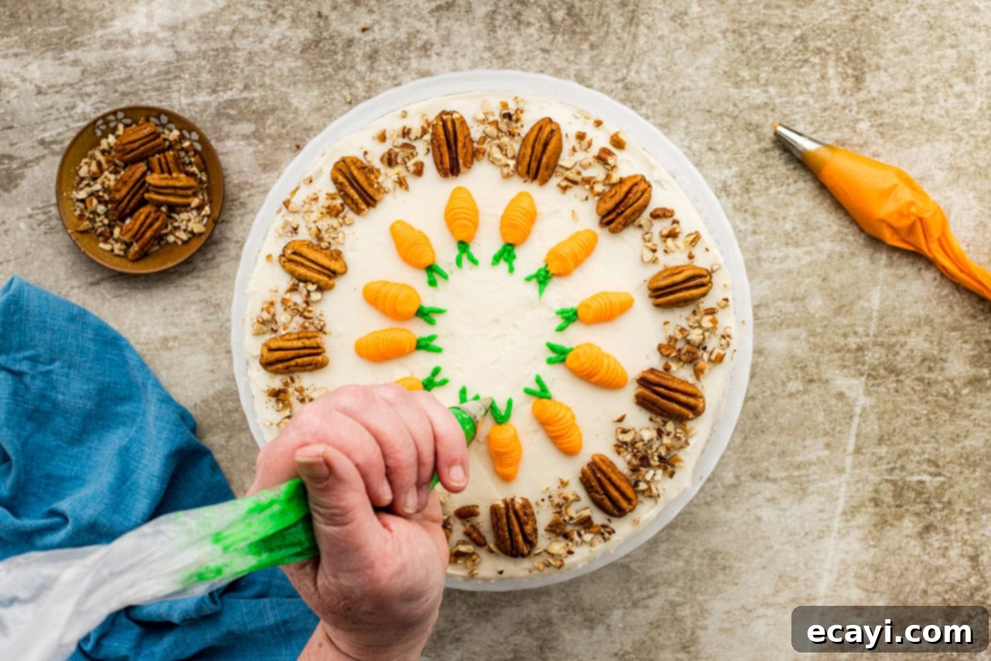 Spiced Carrot Delight 14 A piping bag with green frosting creating small leaf details at the top of a piped orange carrot on the cake surface.