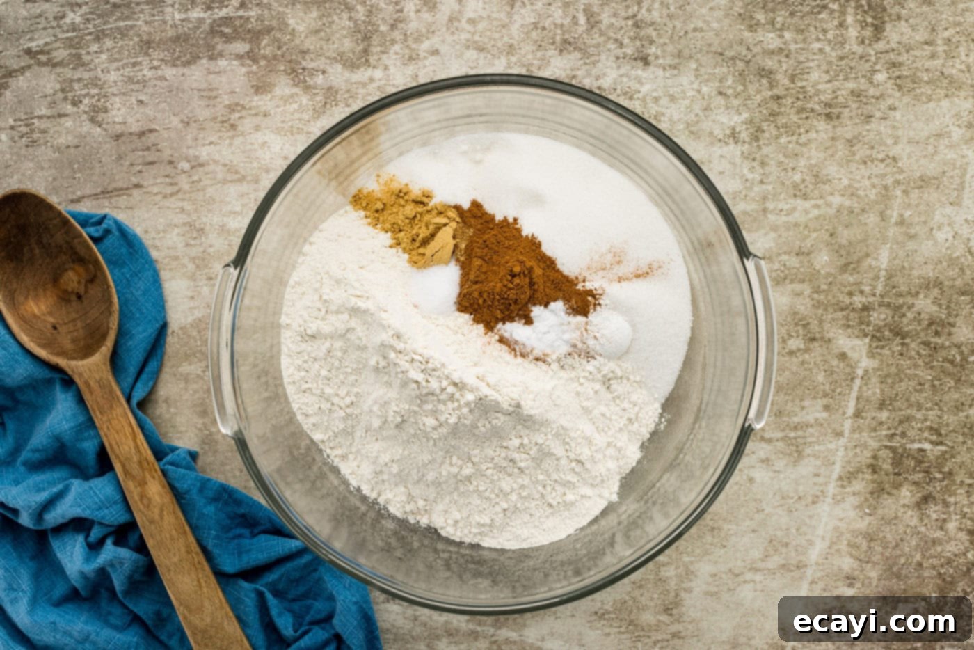 Spiced Carrot Delight 5 Dry ingredients for the moist carrot cake, including flour, sugar, and spices, mixed together in a large white bowl.