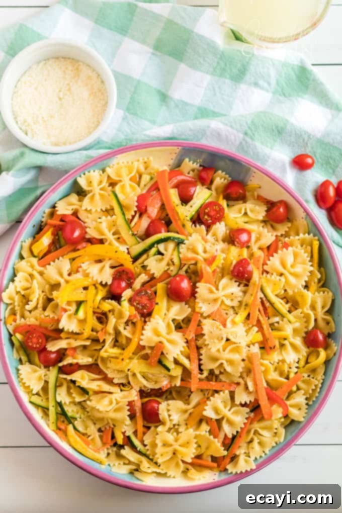 Pasta Primavera is a simple dish, ideal for weeknights, full of fresh vegetables and light on the sauce. A family friendly meal you'll love. #pastaprimavera #pastarecipes #vegetarian #zucchini #bellpeppers #dinner #dinnerrecipes #meatlessmondays big bowl of pasta primavera on table