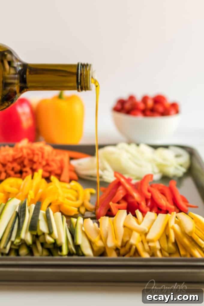 Pasta Primavera is a simple dish, ideal for weeknights, full of fresh vegetables and light on the sauce. A family friendly meal you'll love. #pastaprimavera #pastarecipes #vegetarian #zucchini #bellpeppers #dinner #dinnerrecipes #meatlessmondays pouring olive oil onto fresh vegetables on a pan