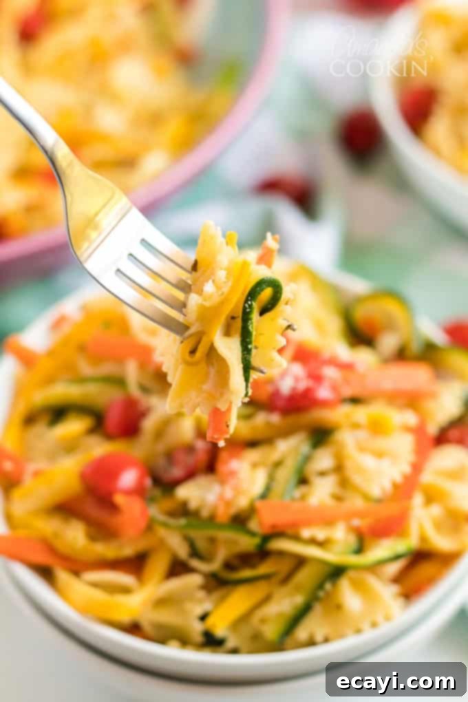 Pasta Primavera is a simple dish, ideal for weeknights, full of fresh vegetables and light on the sauce. A family friendly meal you'll love. #pastaprimavera #pastarecipes #vegetarian #zucchini #bellpeppers #dinner #dinnerrecipes #meatlessmondays forkful of pasta primavera