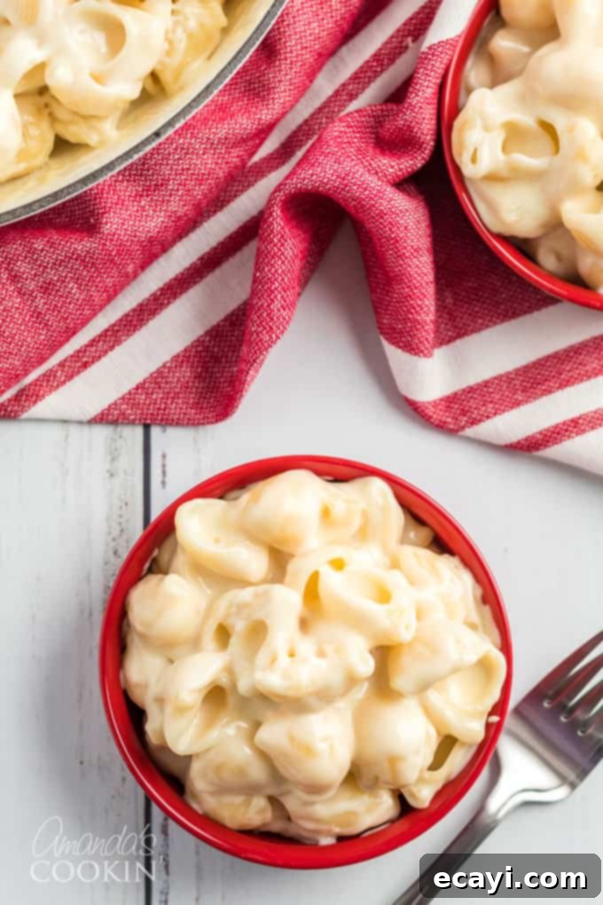 Indulge in the ultimate comfort food! Our copycat Panera mac and cheese recipe delivers creamy, cheesy perfection every time. #panera #macandcheese #macaroni #cheese #copycatrecipes #dinnersides A vibrant red bowl filled to the brim with creamy, golden copycat Panera mac and cheese, ready for a comforting meal.
