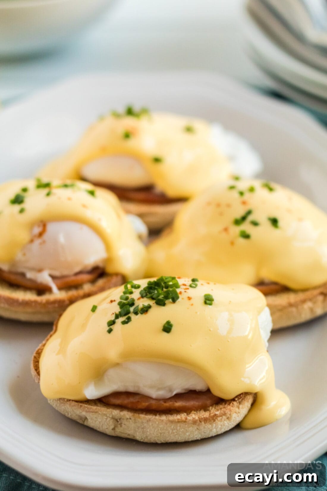 Eggs Benedict is a delicious open-faced English muffin sandwich. Topped with a perfectly poached egg, Canadian bacon, and a rich, creamy hollandaise sauce. #eggsbenedict #breakfast #breakfastrecipes #mothersdayrecipes #brunch #sandwich #breakfastsandwich #hollandaise eggs benedict