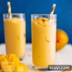 Mango Lassi Delight 2 A glass of creamy Mango Lassi smoothie with a straw.