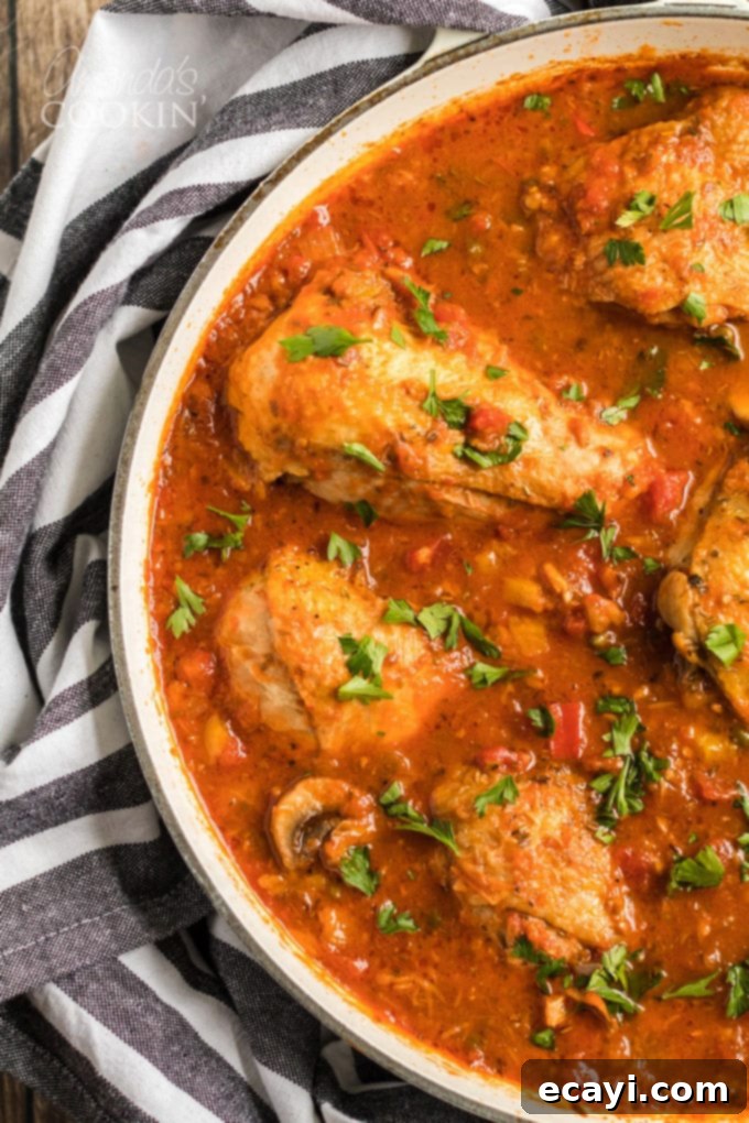 Stovetop Chicken Cacciatore cooking in a pan, a classic stewed chicken recipe with onions, bell peppers, garlic, and capers. Perfect for slow cooking and developing deep Italian flavors. #stovetopdinner #weeknightmeals #dinnerrecipes #chicken #chickencacciatore #bellpeppers #chickendinner #italiancomfortfood chicken cacciatore in pan