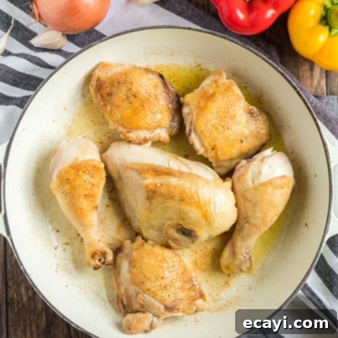 Browned bone-in, skin-on chicken pieces in a Dutch oven, crucial for developing deep flavor in Stovetop Chicken Cacciatore. #chickencacciatore #browningchicken #italianrecipe browned chicken pieces in a pan