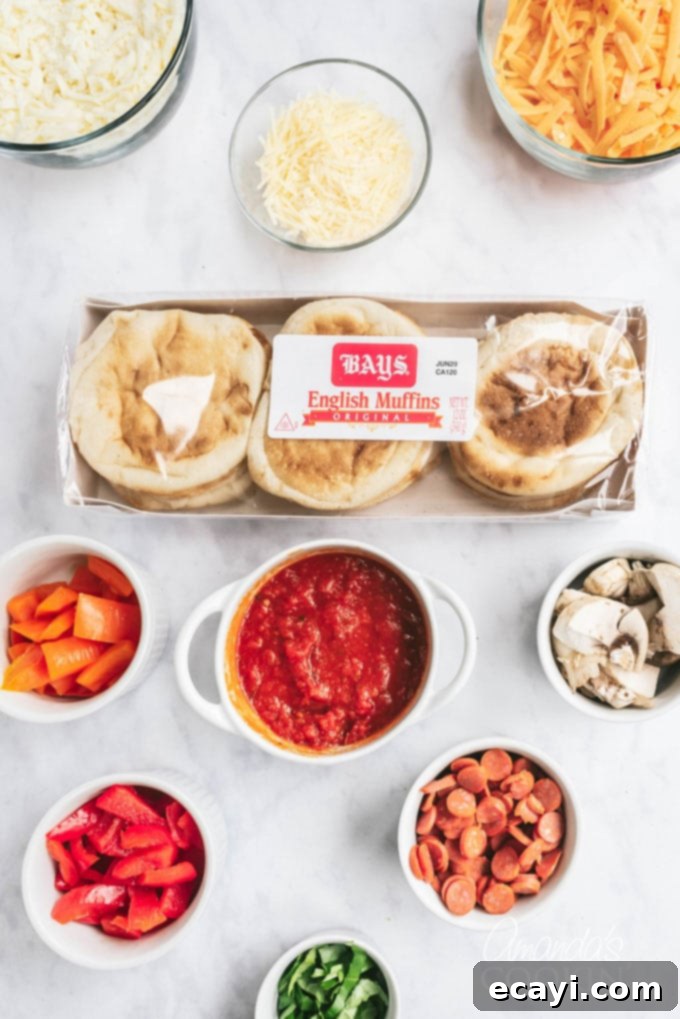 Muffin Pizza Creation Bar 5 Various fresh ingredients for English muffin pizza beautifully laid out on a table, including Bays English muffins, pizza sauce, shredded cheese, and assorted toppings like pepperoni, bell peppers, and olives.