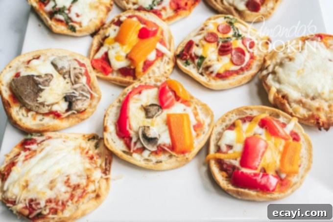 Muffin Pizza Creation Bar 9 A collection of several distinct English muffin pizzas arranged on a baking tray, each with different toppings and perfectly baked, hot and ready to eat