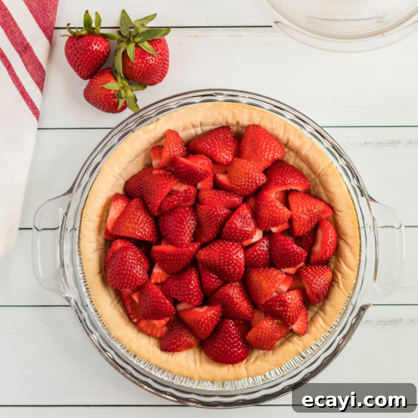 Luscious Strawberry Pie 4 Freshly quartered strawberries neatly arranged within a golden, baked pie crust, forming the base of the delicious strawberry pie.