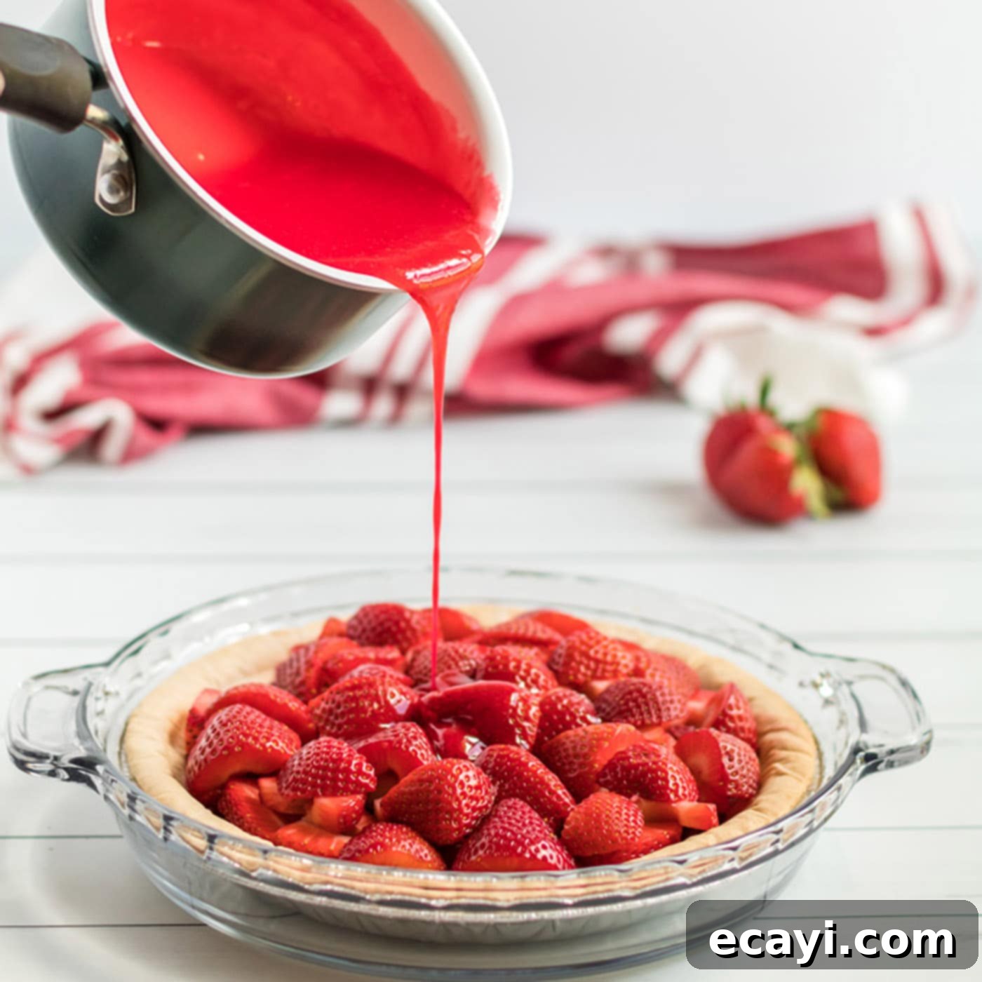 Luscious Strawberry Pie 5 The vibrant red gelatin mixture being carefully poured over the fresh, sliced strawberries in the baked pie crust, ready for chilling.