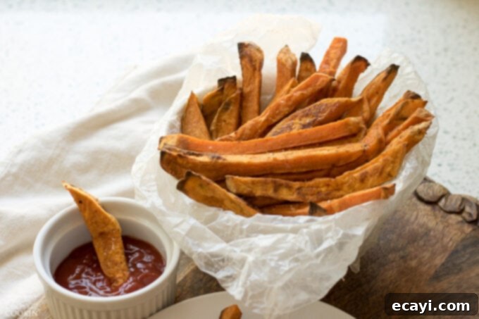 Baked Sweet Potato Fries are a delicious side dish that are good for you! Baking beats frying for this tasty snack, reminiscent of the drive thru. Sweet Potato Fries with a side of ketchup