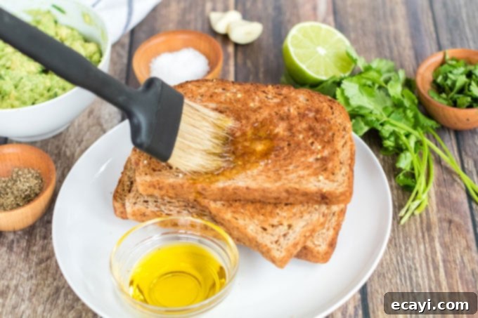Avocado Toast 7 A brush applying olive oil to a slice of freshly toasted bread, preparing it for the avocado topping.