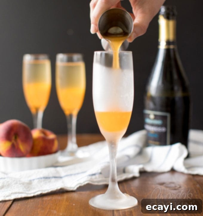 Commonly called a peach bellini, this combination of peach puree and Prosecco is served in a champagne flute and garnished with a fresh peach wedge. pouring peach puree into a champagne flute