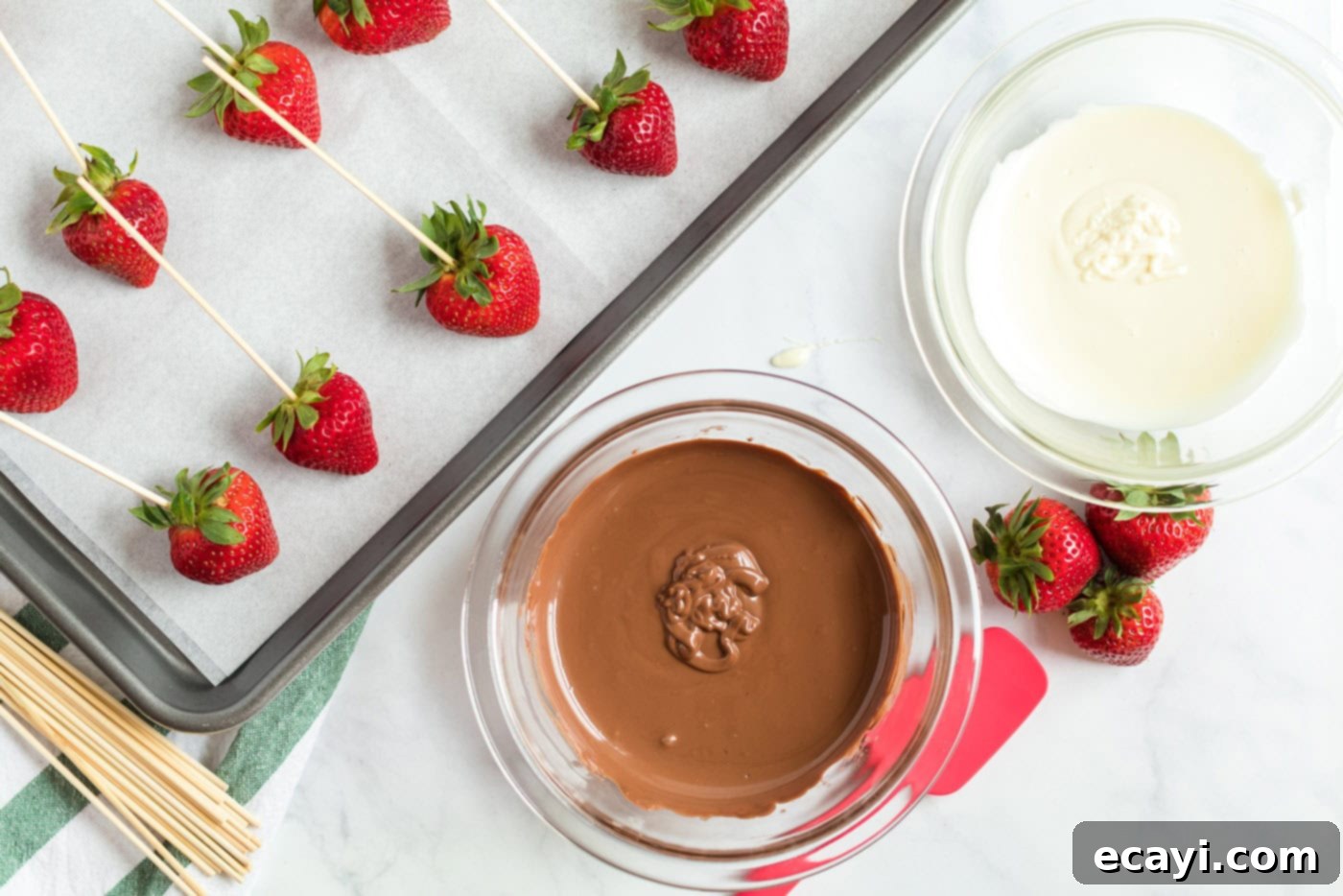 Indulgent Chocolate-Dipped Strawberries 5 strawberries skewered on a pan and a bowl of melted chocolate