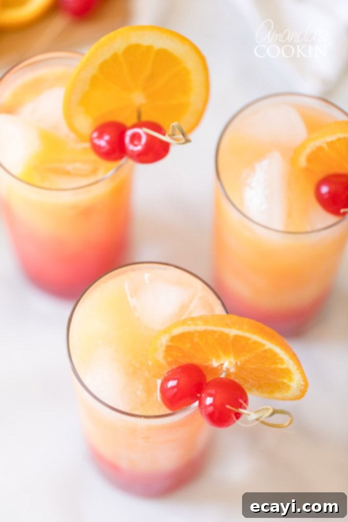 Perfect Tequila Sunrise: A Step-by-Step Cocktail Guide Overhead shot of beautifully garnished Tequila Sunrise drinks, showcasing the vibrant layered colors and inviting presentation, ready to be enjoyed.