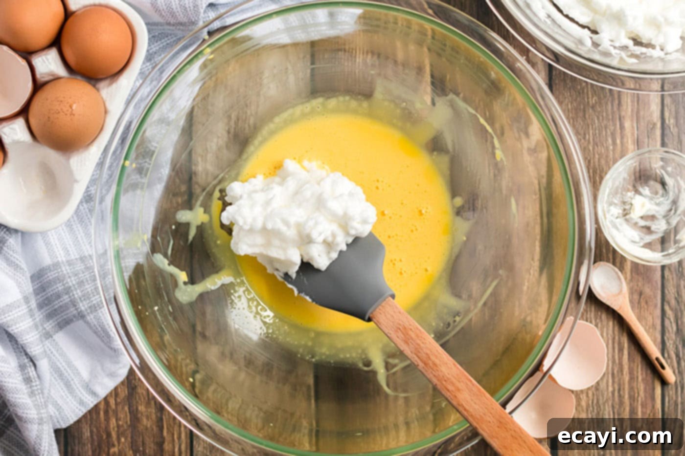 Airy Cloud Dream 7 A scoop of light egg white mixture being gently folded into the rich egg yolk mixture