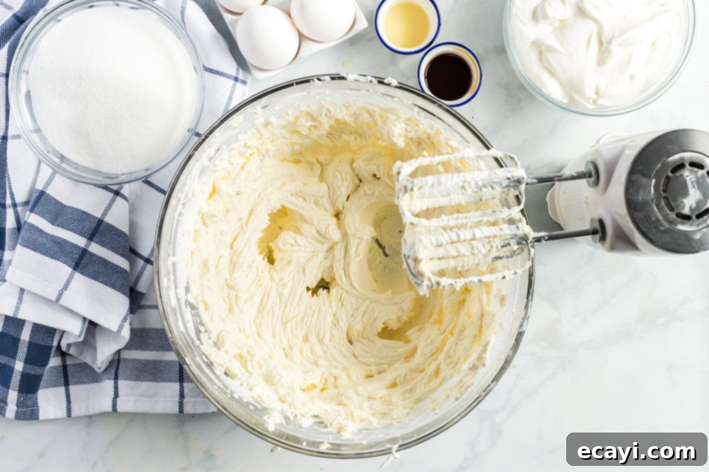 Decadent Cherry Cheesecake 6 Electric mixer beating softened cream cheese and sugar in a large bowl, creating a smooth batter.