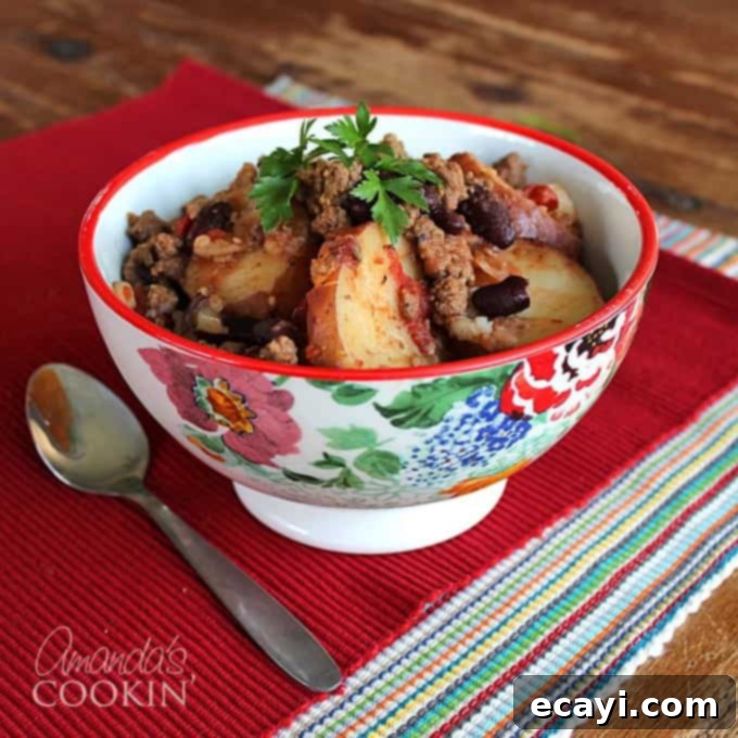 Chuck Wagon Comfort 2 A multicolored bowl filled with cowboy casserole and a spoon on the side.