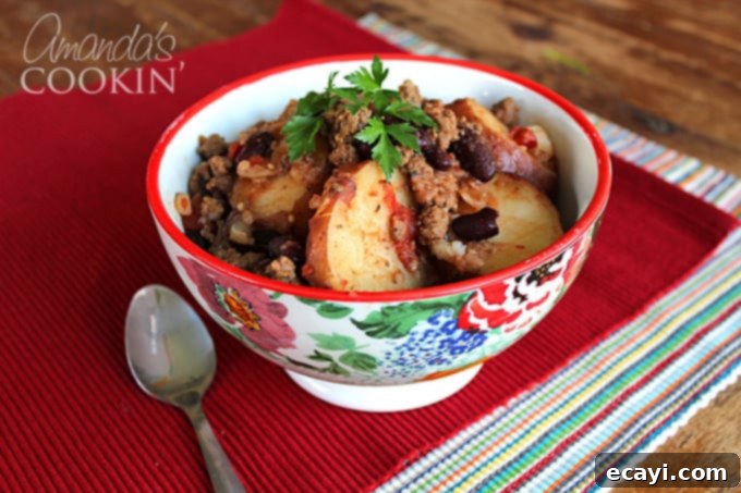 Chuck Wagon Comfort 4 A multicolored bowl filled with cowboy casserole and a spoon on the side.