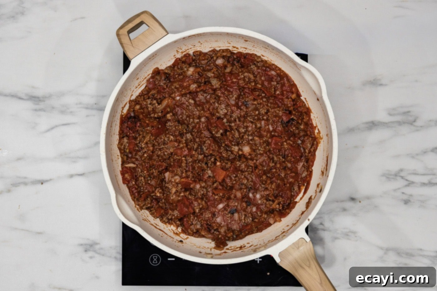 Classic Italian Lasagna 6 Rich and savory lasagna meat sauce mixture bubbling gently in a large skillet, showcasing its vibrant red color and texture.
