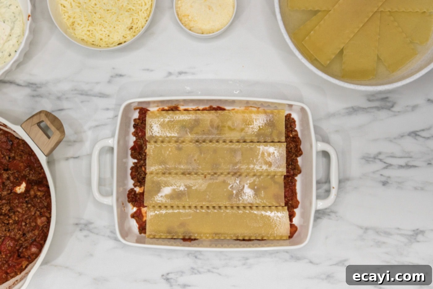 Classic Italian Lasagna 10 Softened lasagna noodles carefully placed over the meat sauce layer in a casserole dish, forming a smooth foundation.