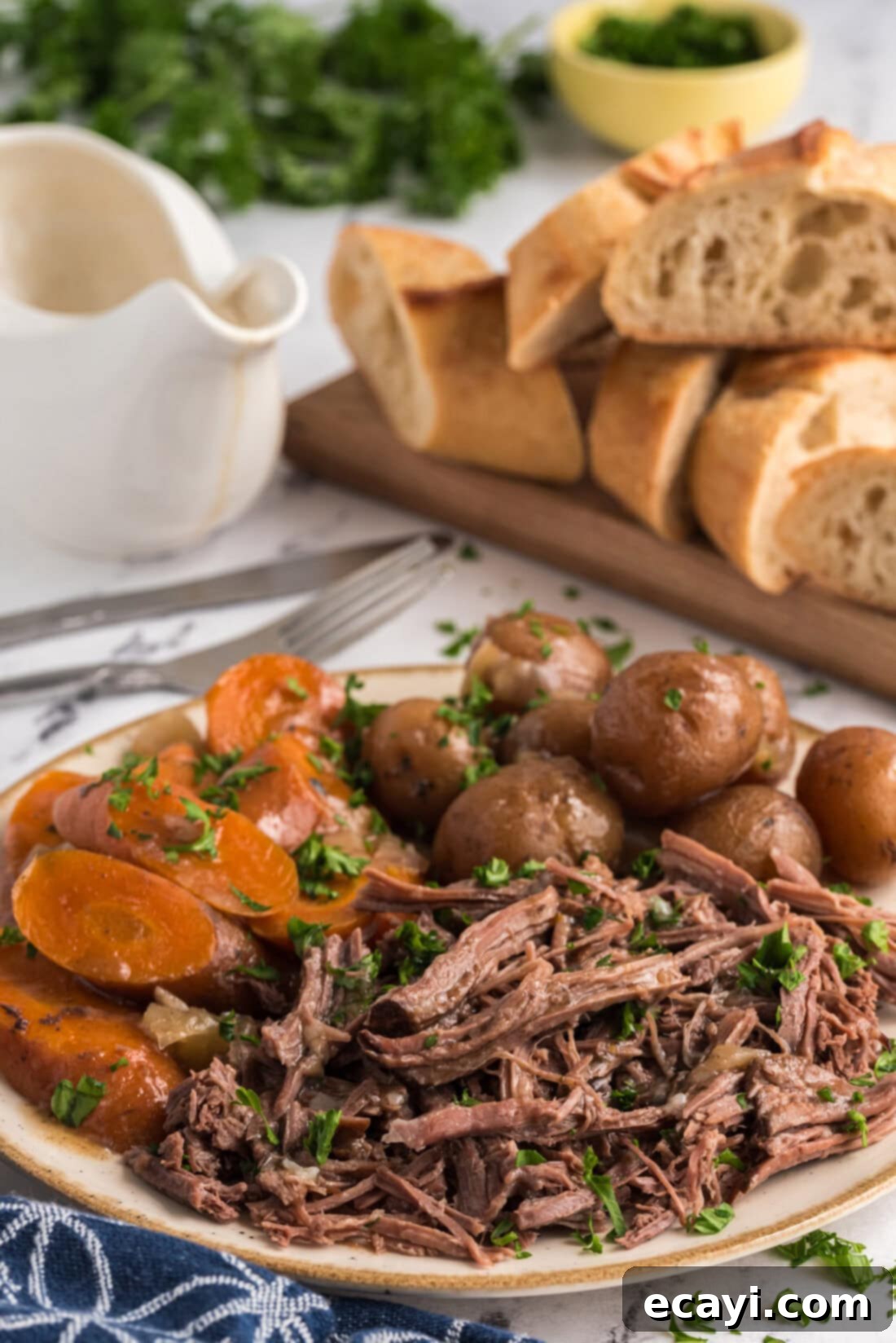 Melt-in-Your-Mouth Slow Cooker Pot Roast 14 Shredded Crockpot Roast Beef beautifully arranged on a platter with soft potatoes and vibrant carrots