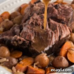Melt-in-Your-Mouth Slow Cooker Pot Roast 15 gracy pouring on crockpot roast beef on a platter