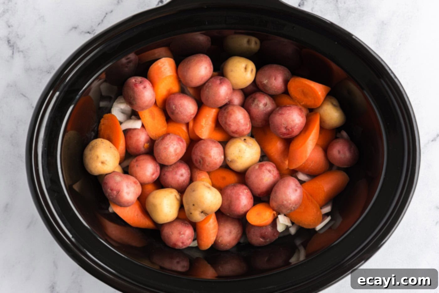 Melt-in-Your-Mouth Slow Cooker Pot Roast 6 Baby potatoes and carrots added on top of the onions in the slow cooker crock