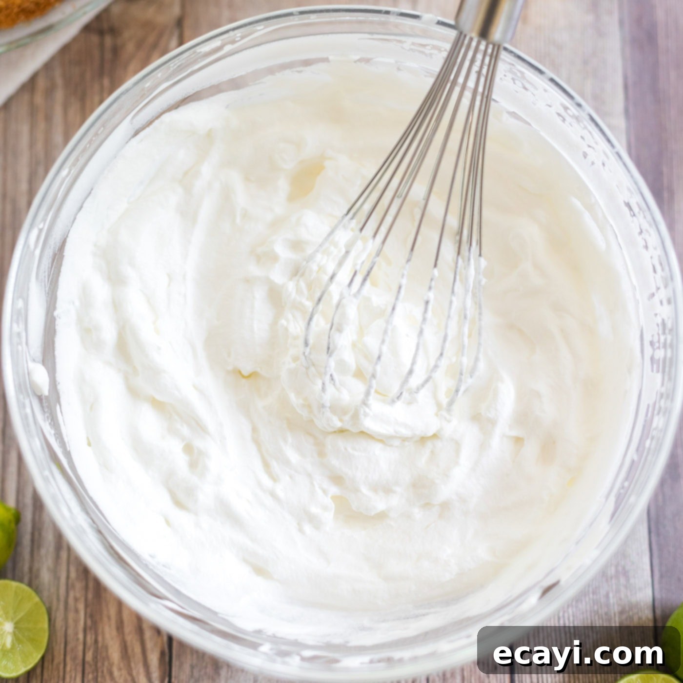 Classic Key Lime Pie 7 whipped cream with a whisk in it