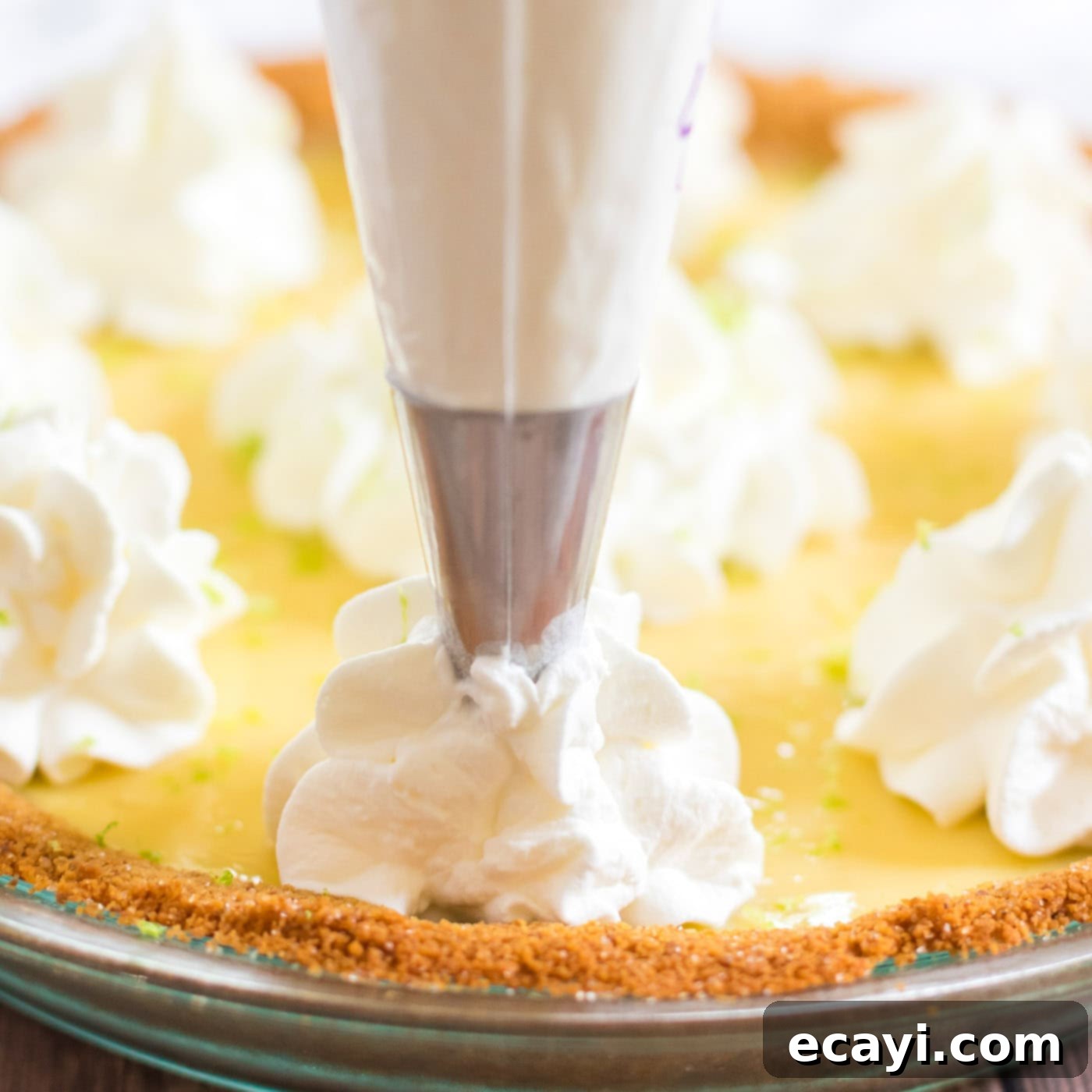 Classic Key Lime Pie 8 piping whipped cream on to key lime pie