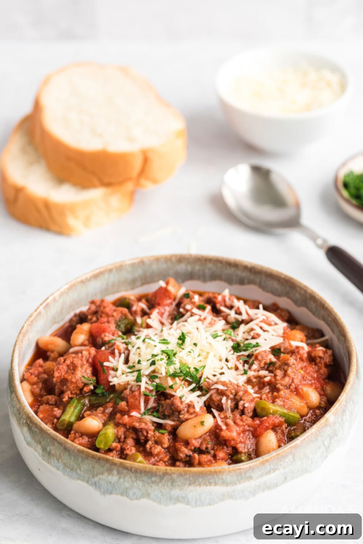 Italian Hamburger Stew Served with Warm Crusty Bread A bowl of comforting Italian hamburger stew with a side of warm Italian bread slices, ready to be enjoyed, highlighting its hearty and inviting nature.