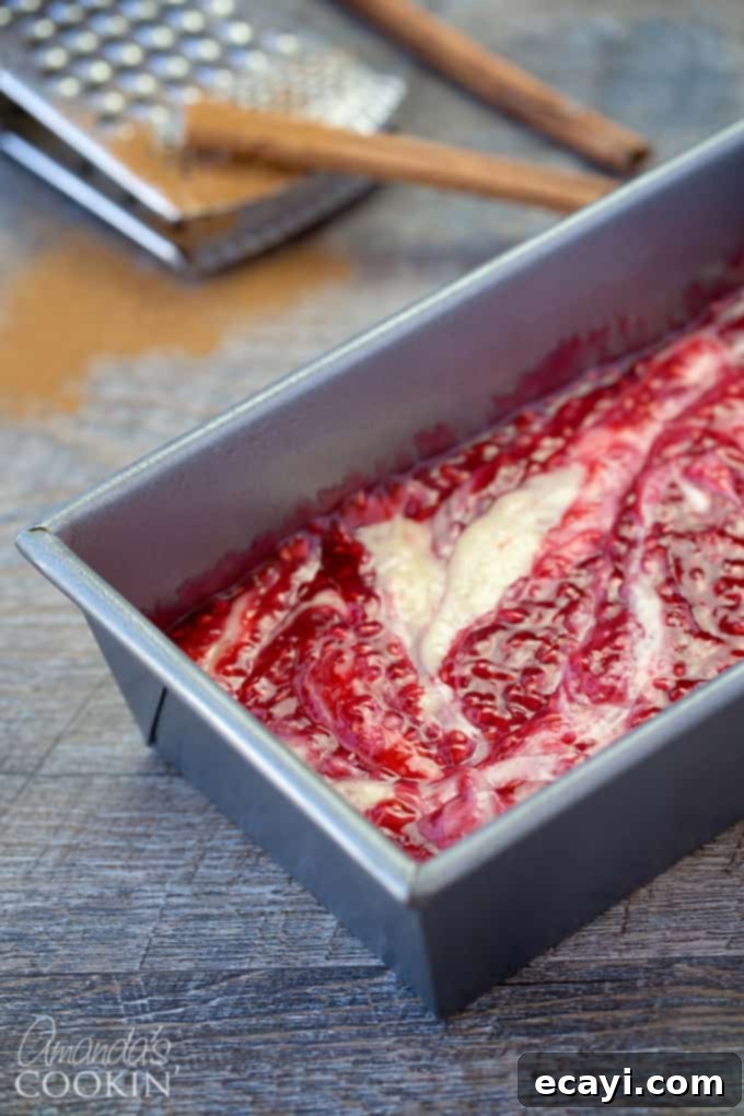 Tangy Raspberry Swirl Coffee Cake 7 A loaf pan showcasing the coffee cake batter with the vibrant raspberry filling poured over the top, ready for swirling.