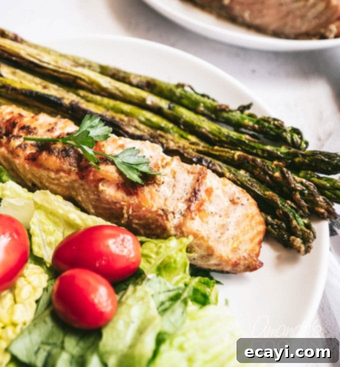Chargrilled Salmon Bliss 3 grilled salmon steak on a plate with grilled asparagus and salad