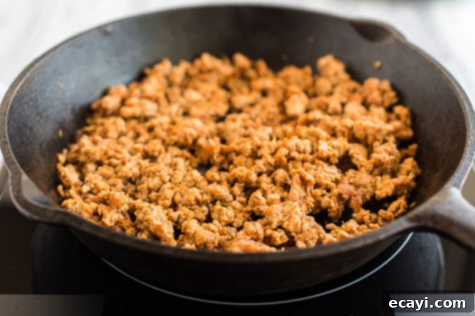 Crafting Authentic Pizza Sausage 8 Golden-brown ground pizza sausage, perfectly cooked, resting in a cast iron skillet, ready to be added as a delicious topping.